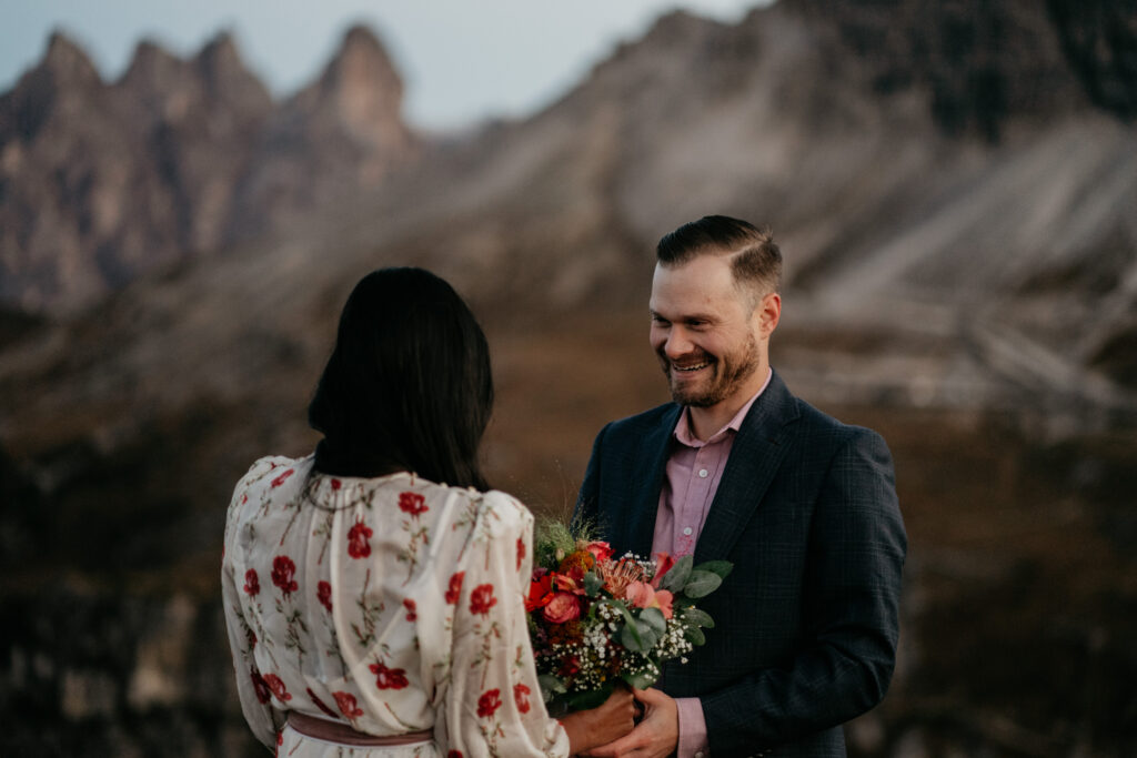 Couple exchanging flowers in mountainous landscape