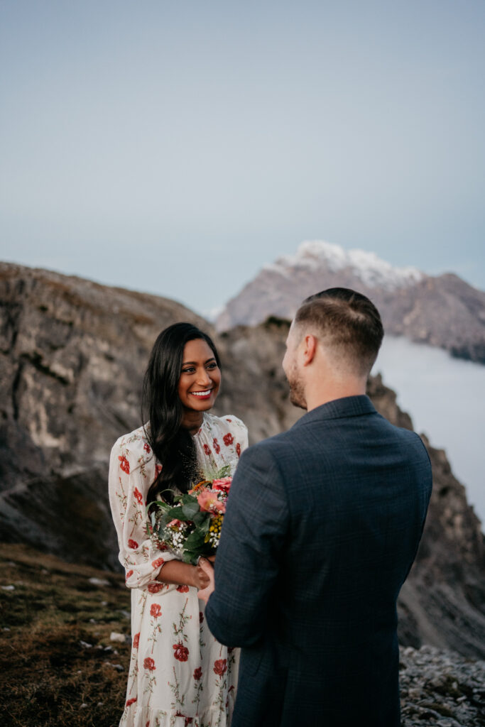 Couple exchanging vows on mountain backdrop