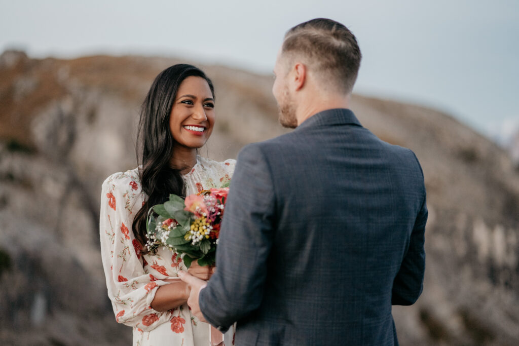 Couple smiling during outdoor wedding ceremony.