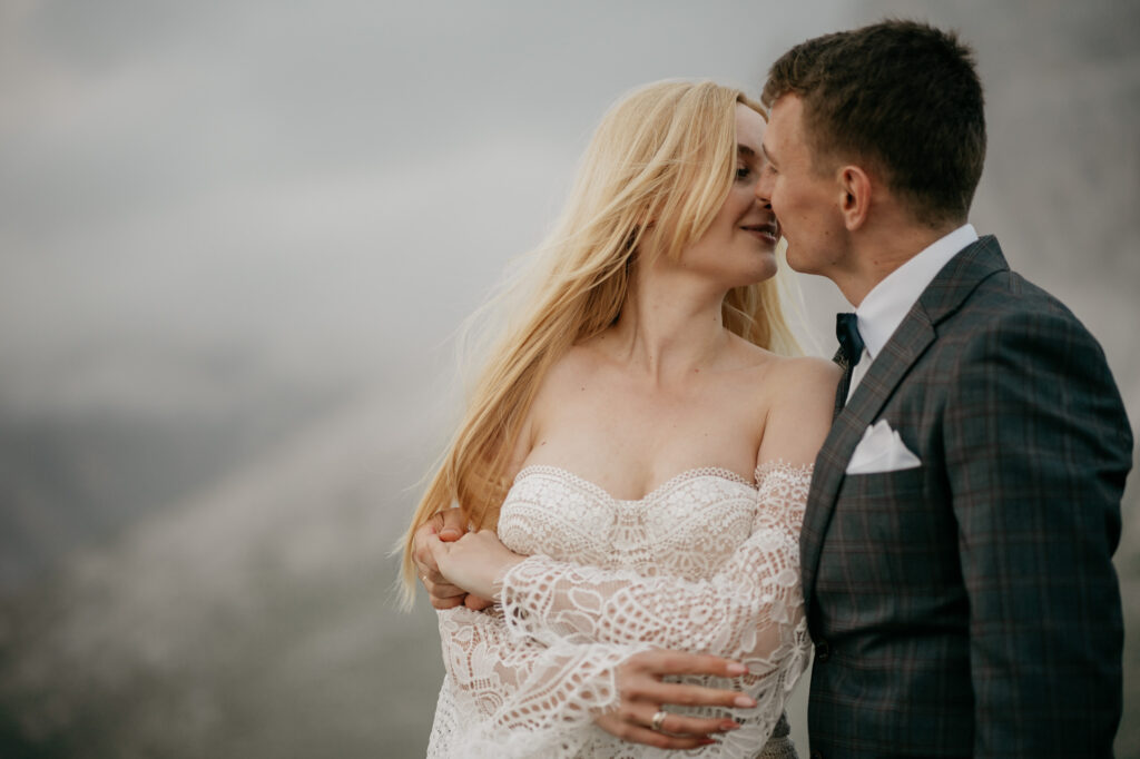 Bride and groom kissing outdoors.