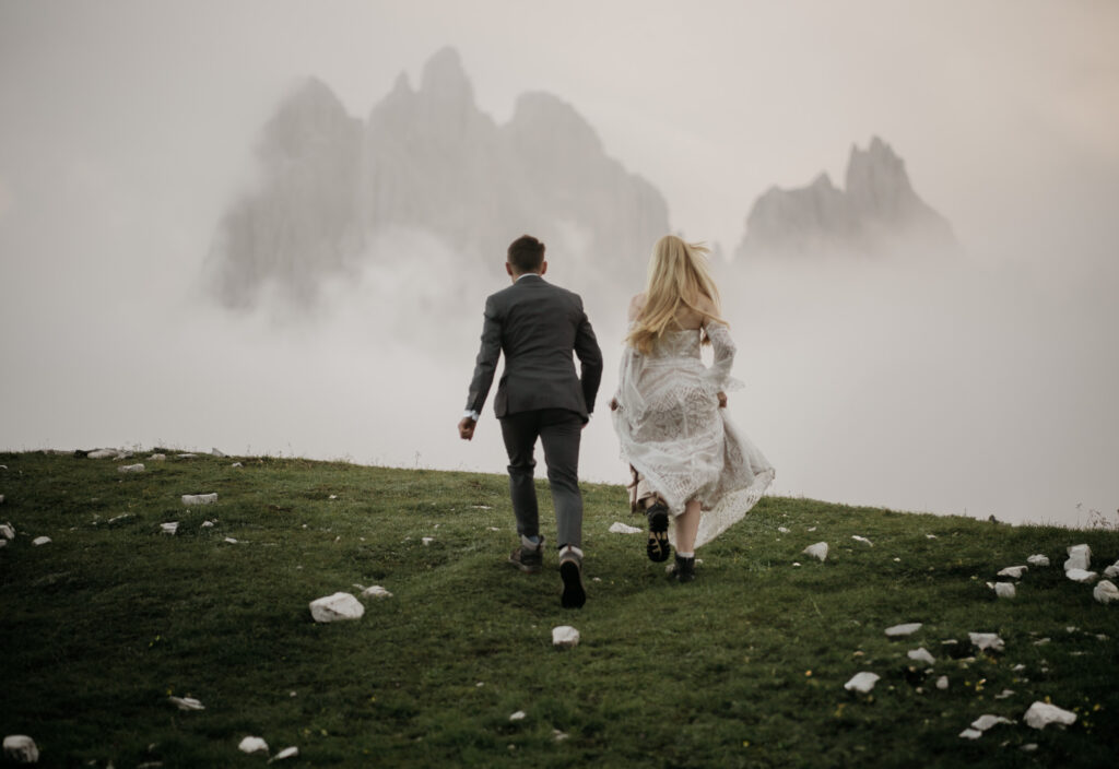 Couple running towards misty mountains