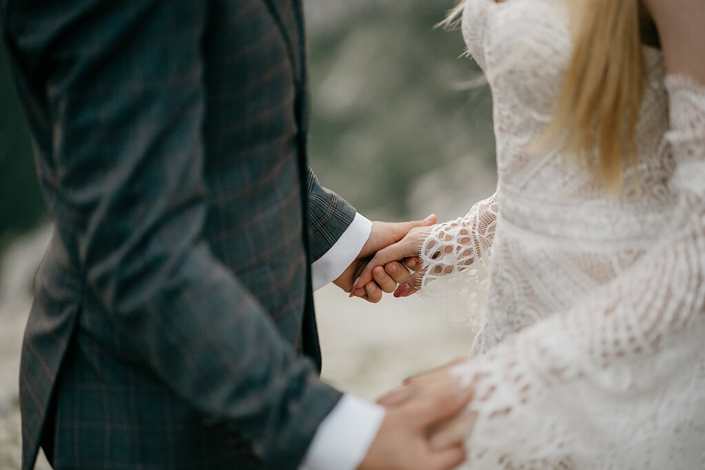 Couple in wedding attire holding hands