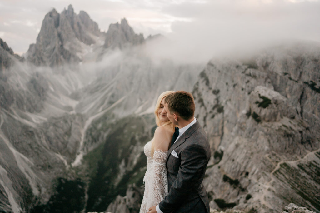 Couple embraces in misty mountain landscape