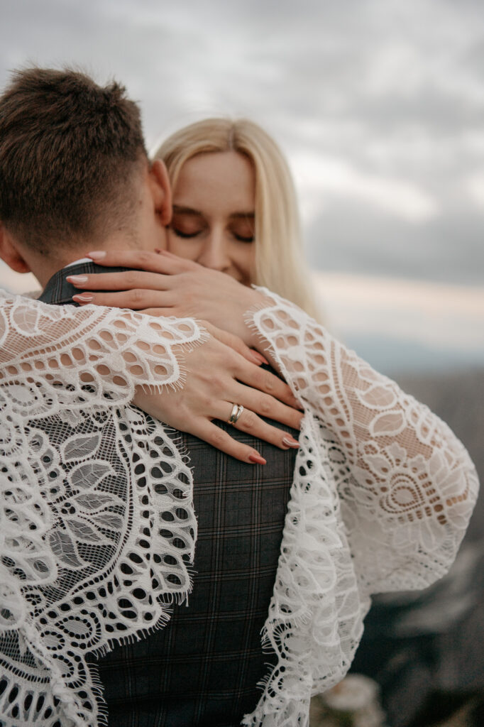 Couple embracing with lace dress and suit.