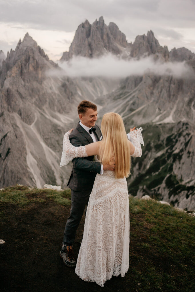 Couple embracing in front of mountain landscape.