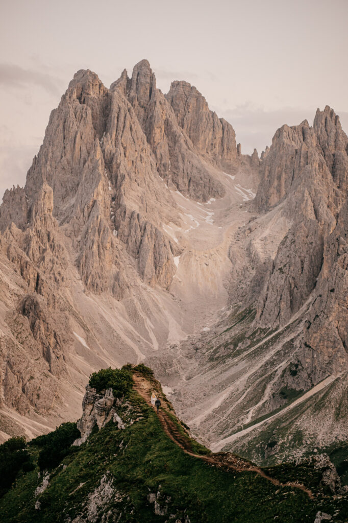 Hiker on trail with towering mountain backdrop