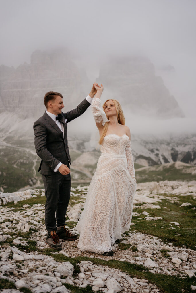 Bride and groom dancing on rocky landscape