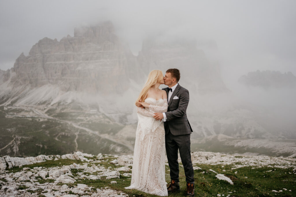 Couple kissing in misty mountain landscape