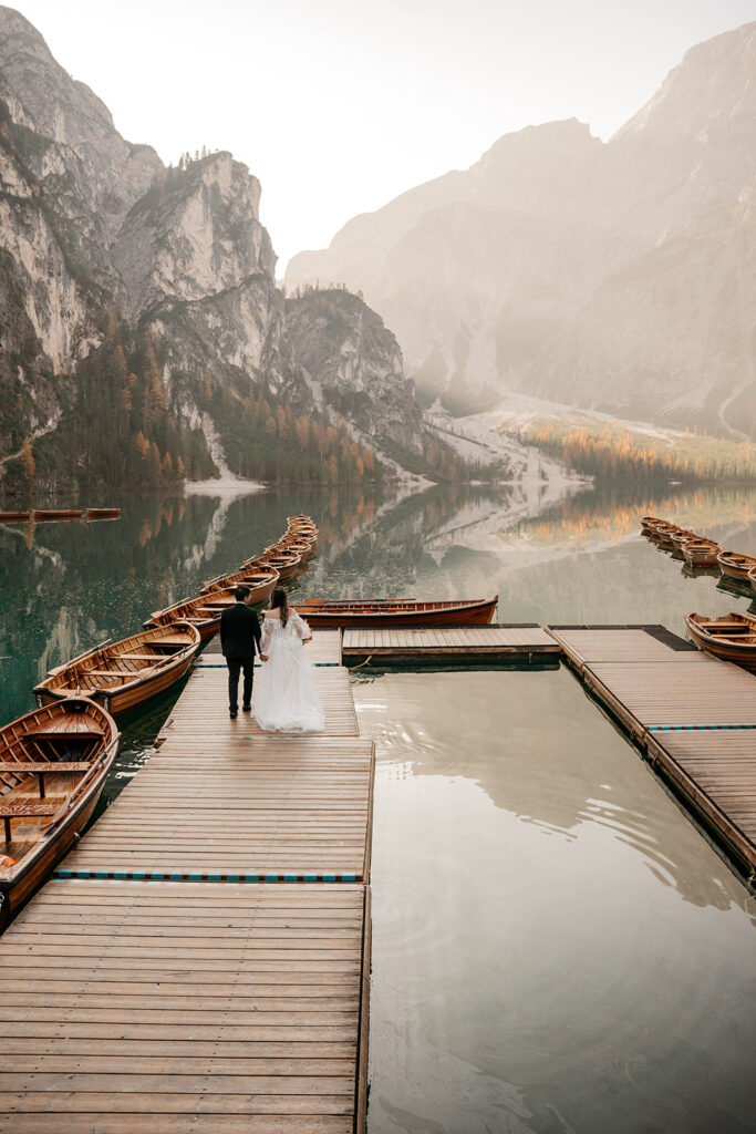 Couple walking on dock by mountain lake