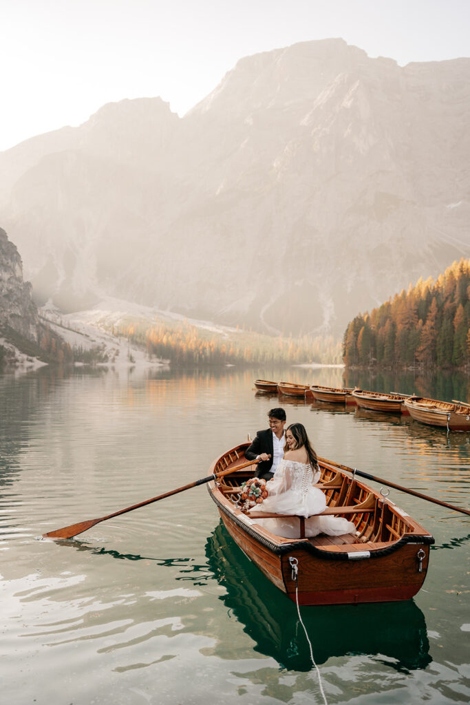 Couple in boat on serene mountain lake.