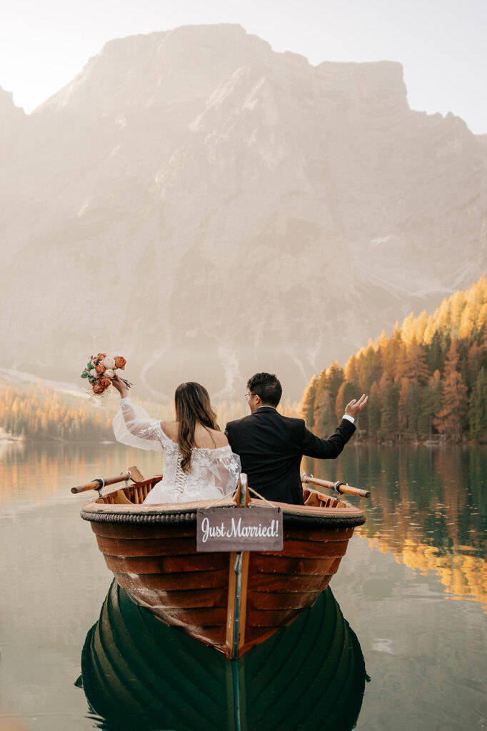 Just married couple rowing on a mountain lake.