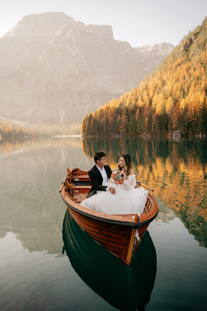 Couple in boat on serene mountain lake.