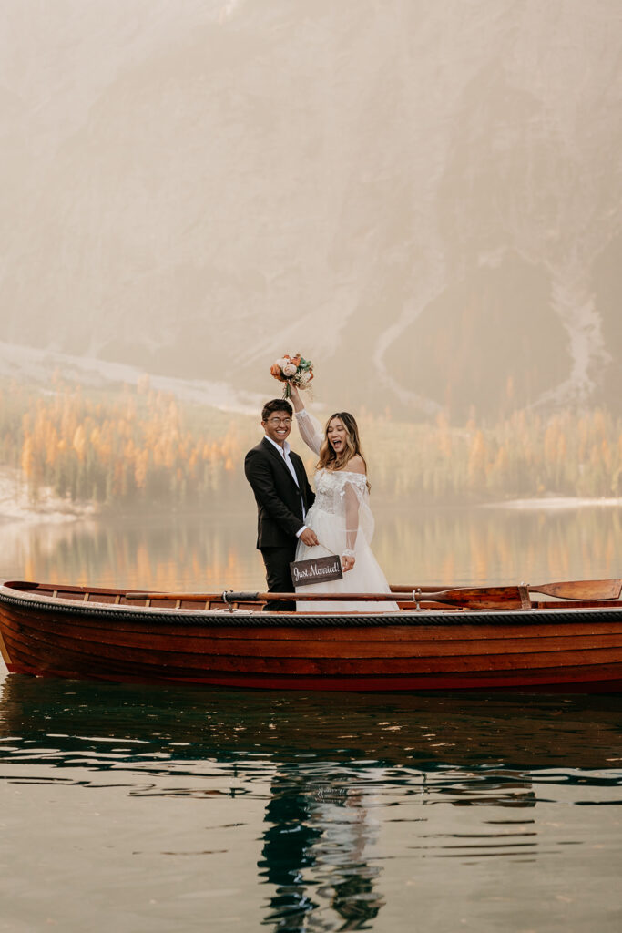 Couple in wedding attire on a boat.