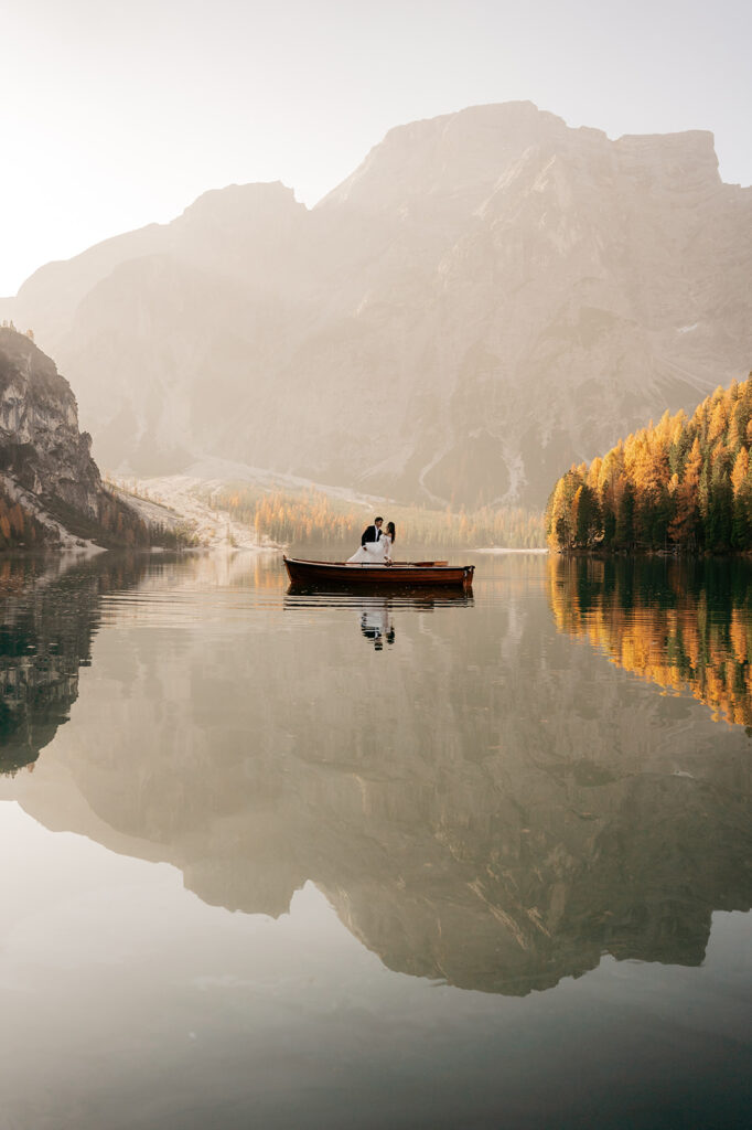 Couple in boat on calm mountain lake.