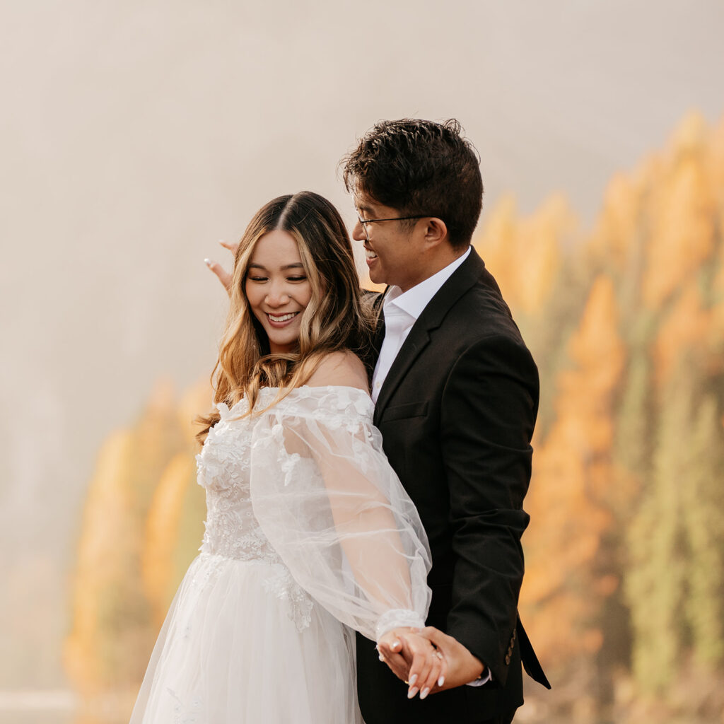 Couple embracing outdoors with autumn trees background.