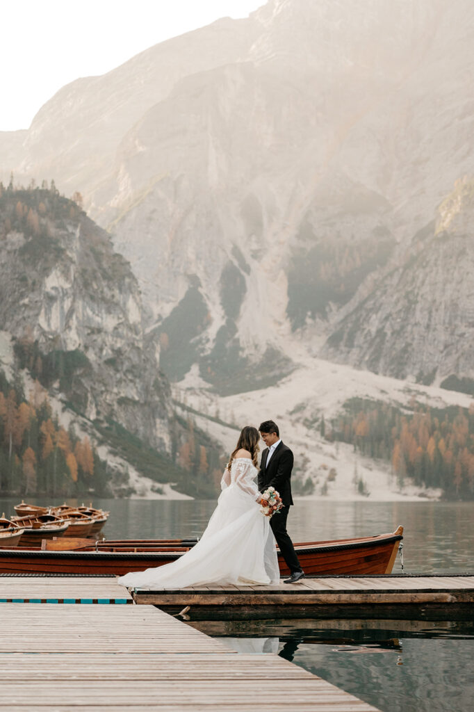 Bride and groom on mountain lake dock