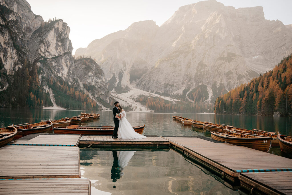 Wedding couple on dock by mountain lake