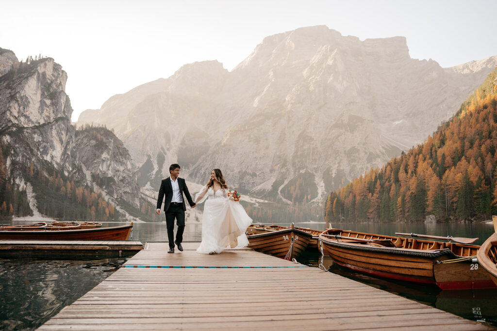 Couple walking on dock in mountain scenery.