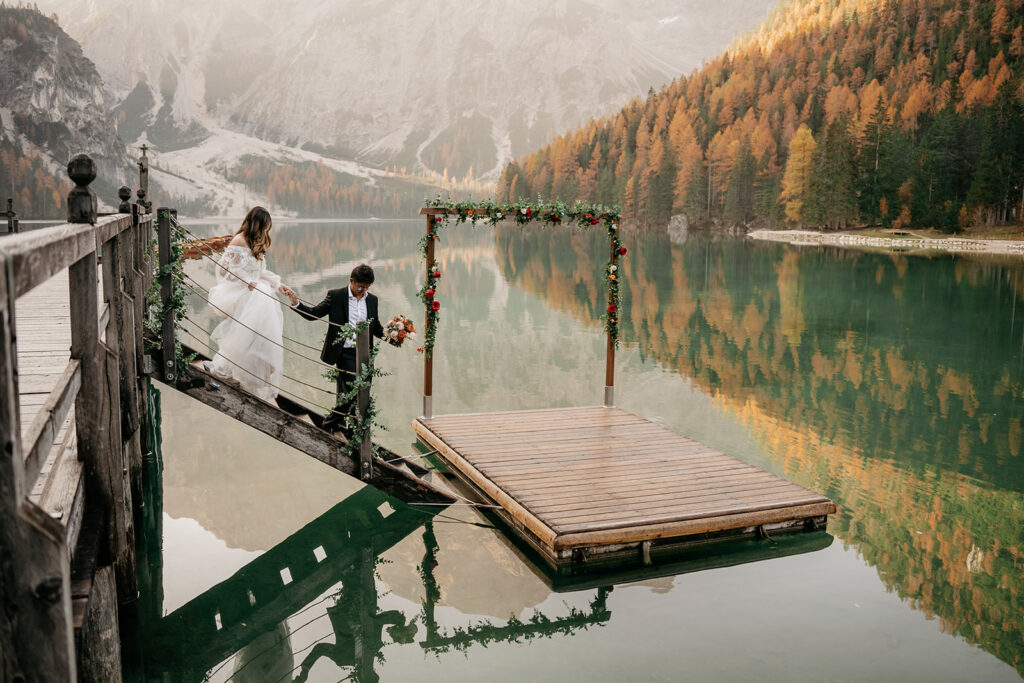 Bride and groom on wooden lake dock