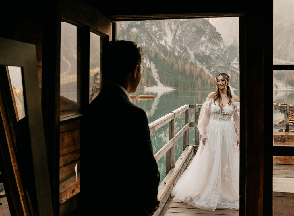 Bride and groom on lakeside balcony.