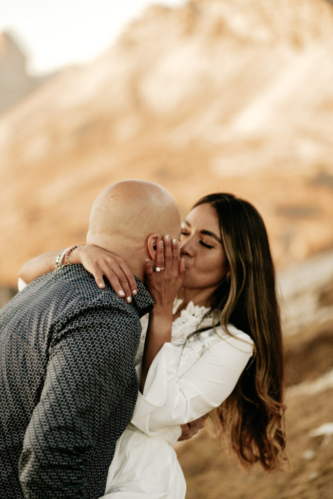 Couple sharing a kiss at sunset.