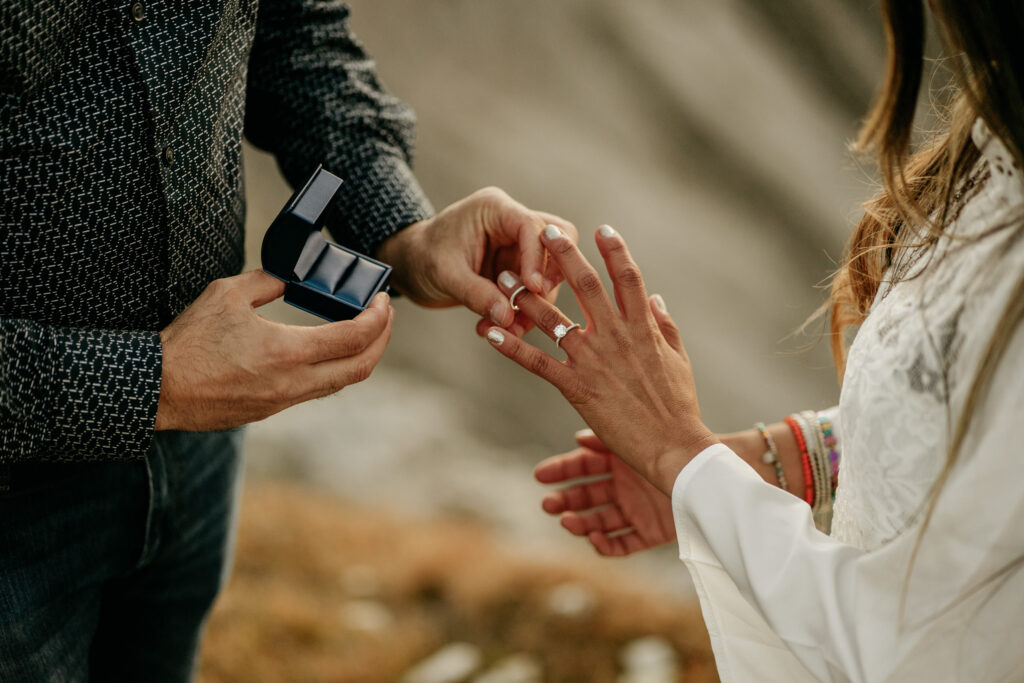 Man proposing with engagement ring outdoors.