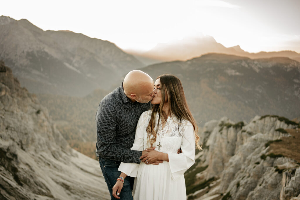 Couple kissing in mountains at sunset