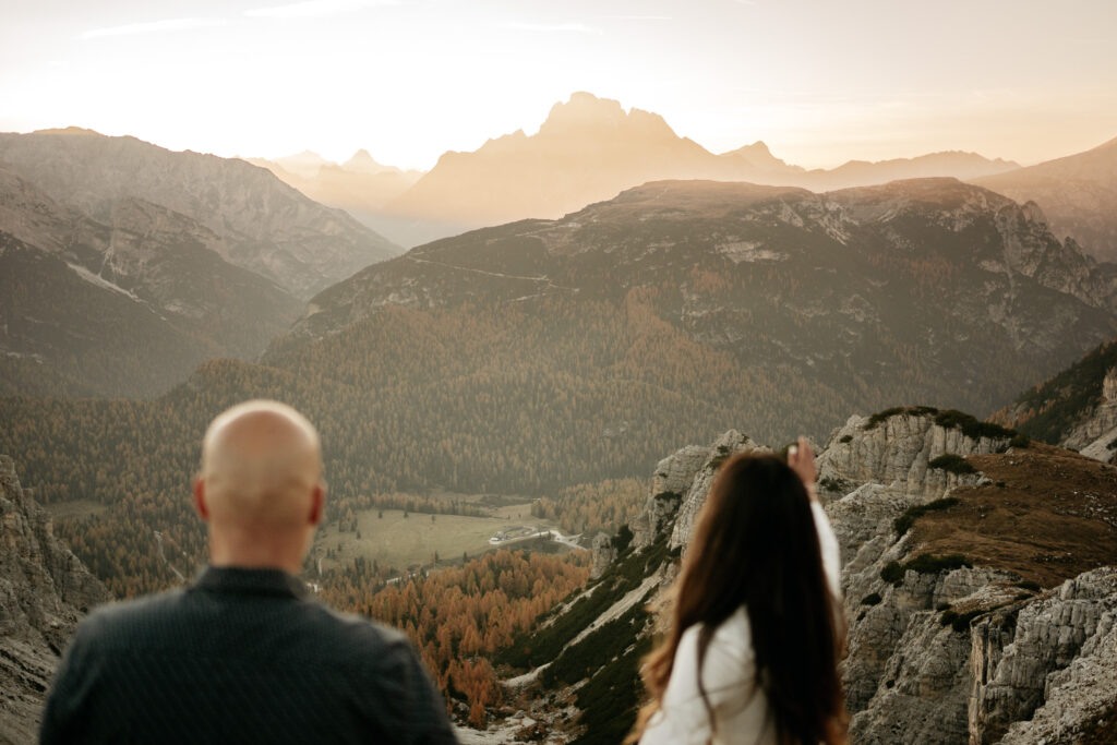 Couple admiring mountain view at sunrise.