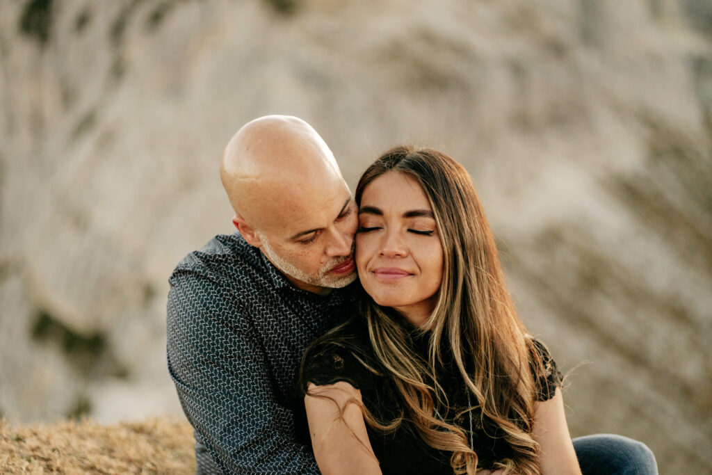 Couple embracing outdoors, serene moment together.