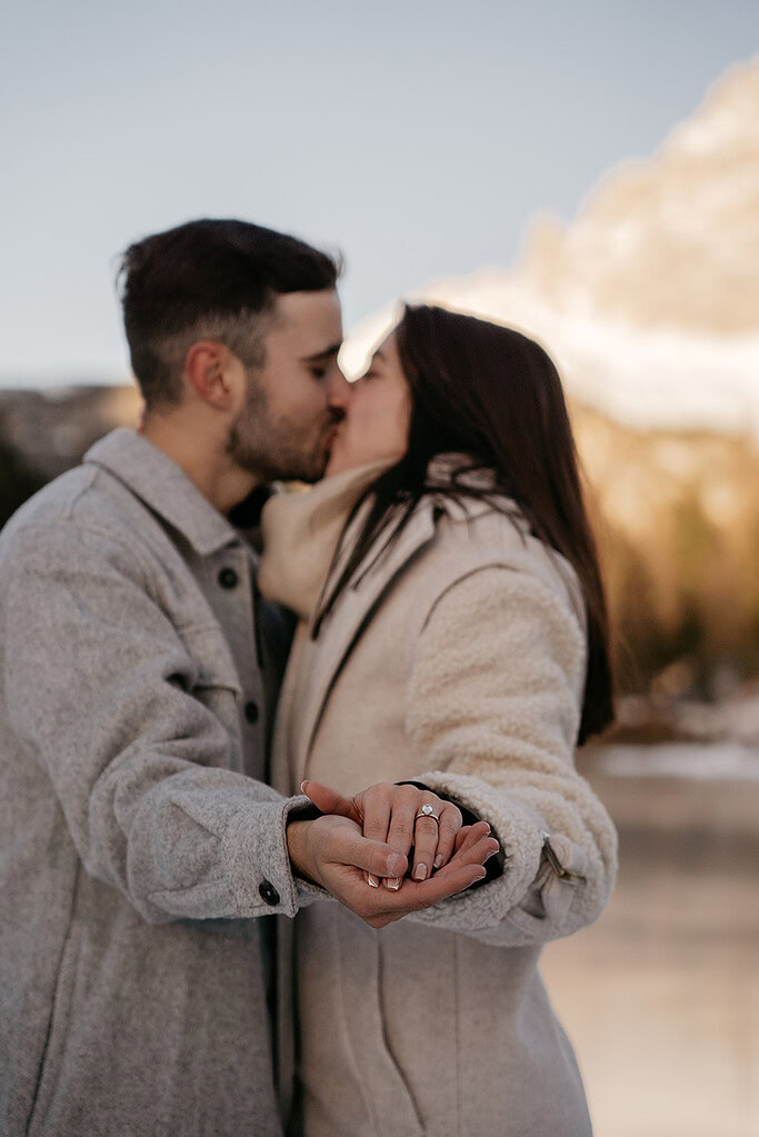 Couple kissing, showing engagement ring