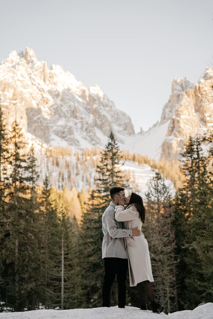 Couple kissing in snowy mountain forest