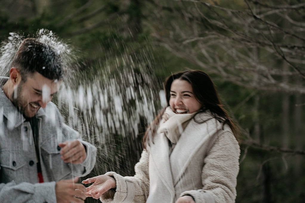 Laughing friends playing in the snow outside