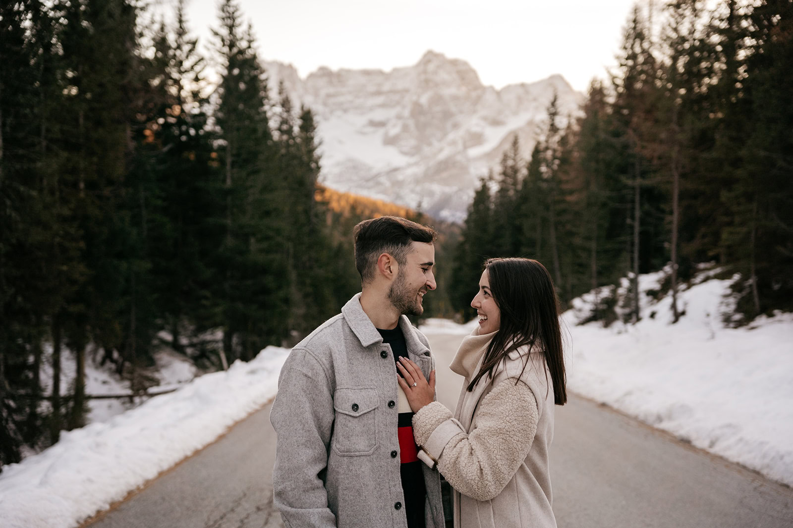 Couple smiling on snowy mountain road