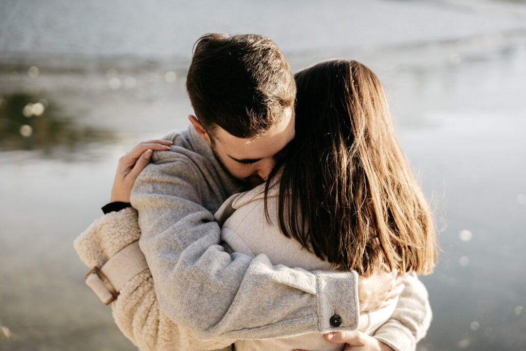 Couple hugging by a serene lake