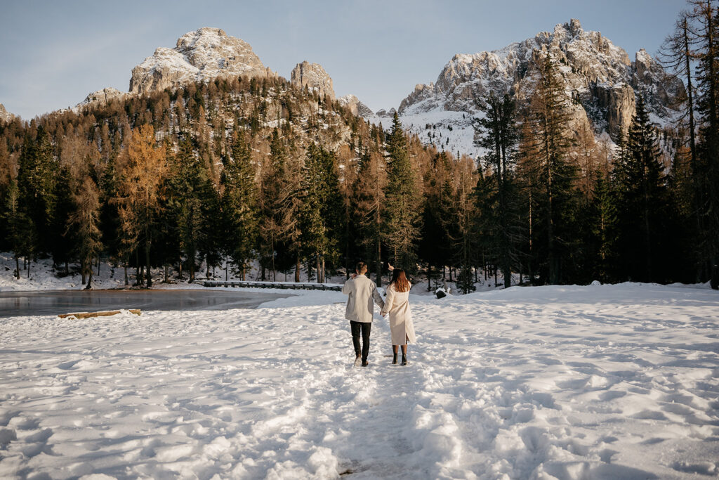 Couple walking in snowy forest mountain landscape