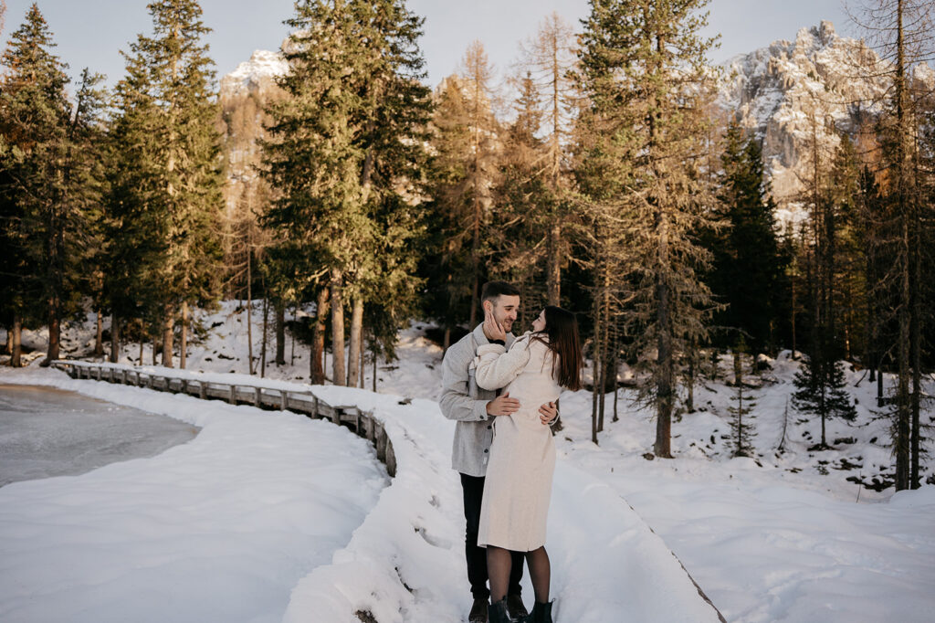 Couple embraces in snowy forest landscape