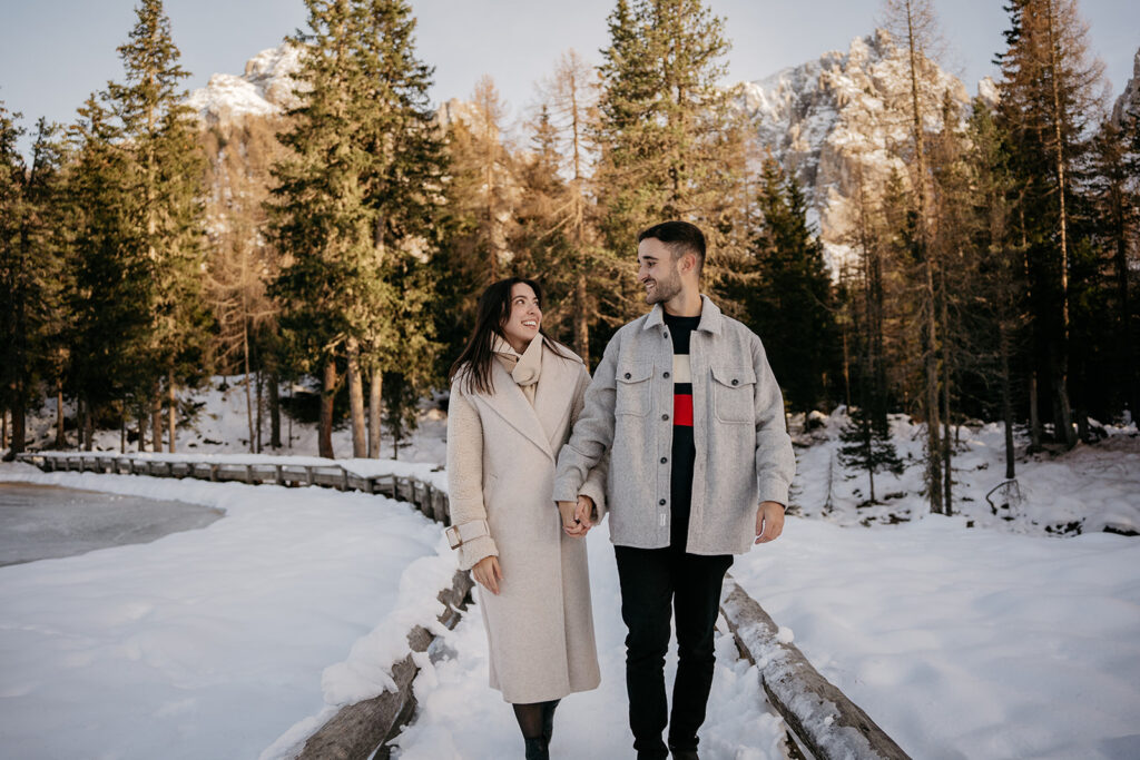 Couple walking in snowy forest trail