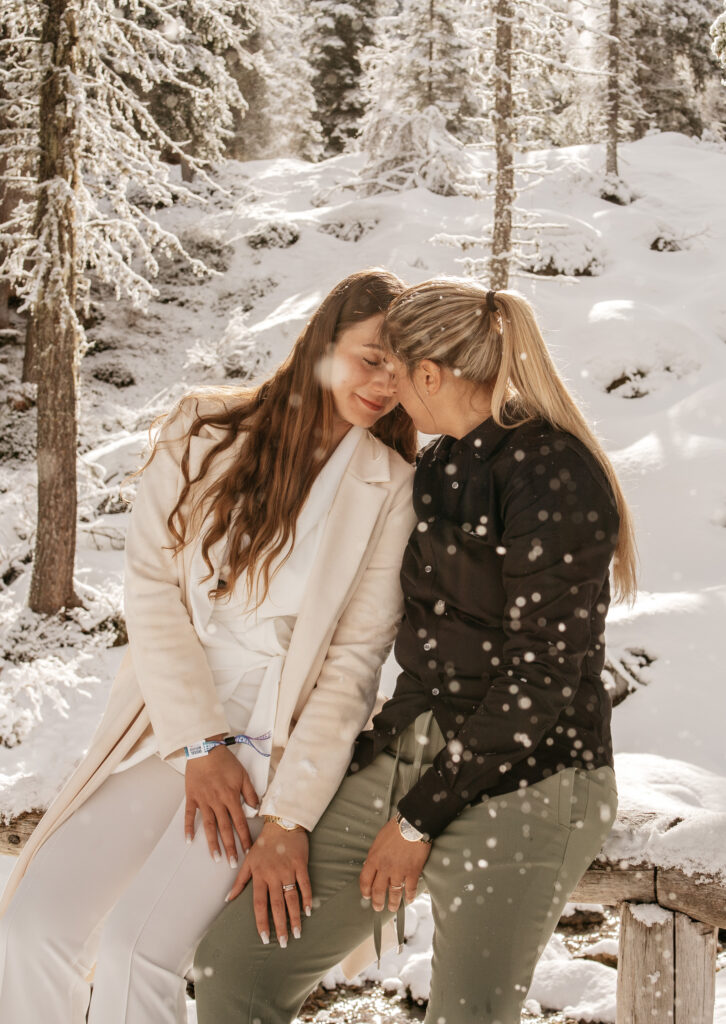 Two women embracing in snowy forest scene