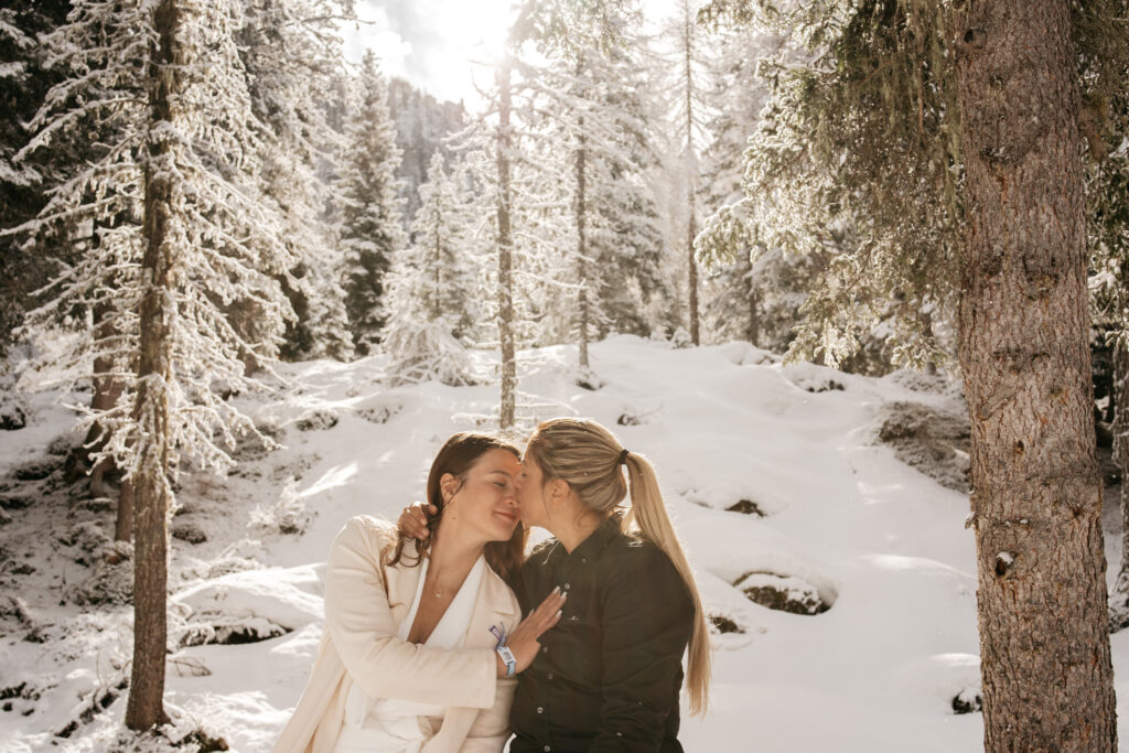 Couple kissing in snowy forest setting