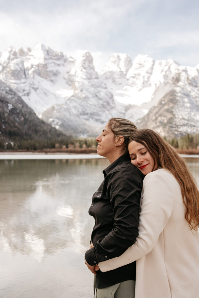 Couple embracing by snowy mountain lake