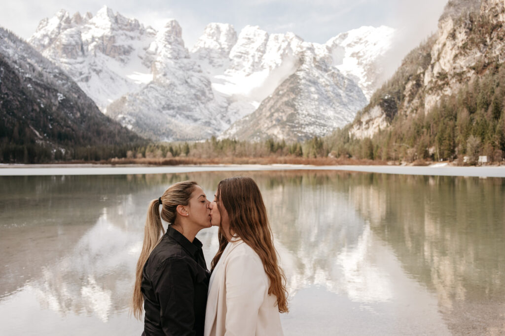 Couple kissing by a scenic mountain lake