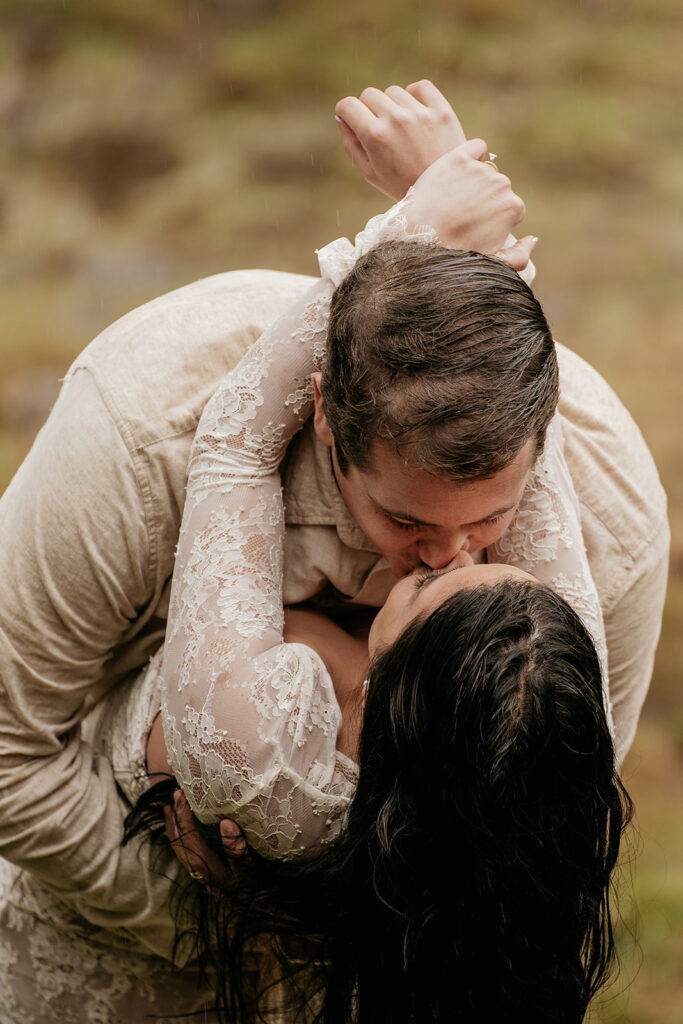 Couple in romantic embrace and kiss outdoors.