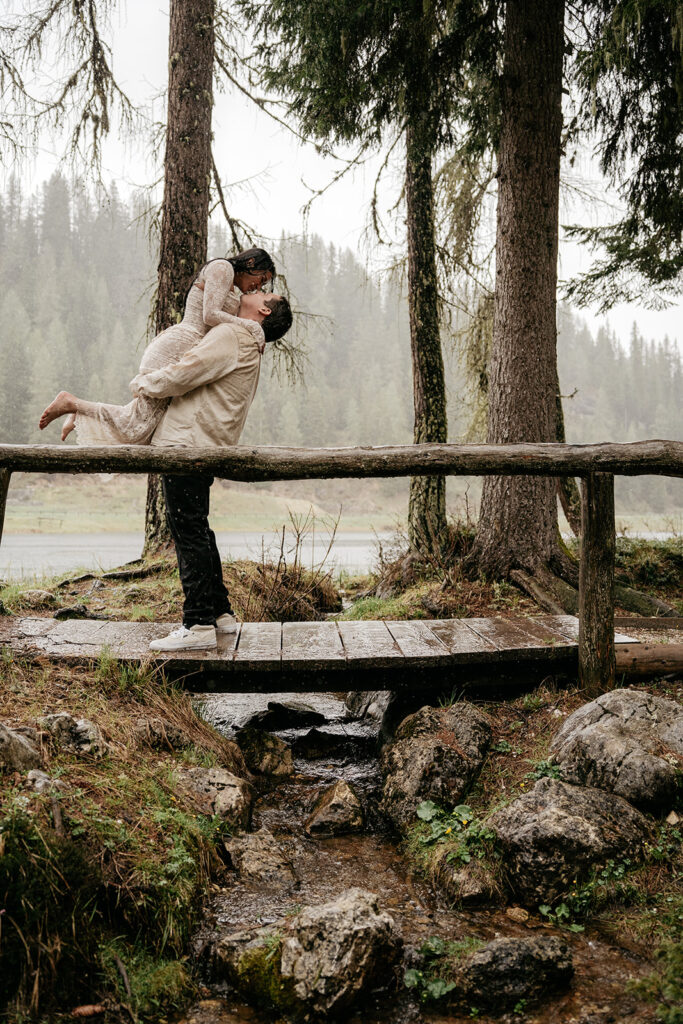 Couple embracing on a wooden bridge in forest