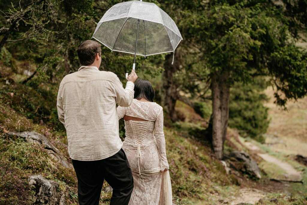 Couple walking with umbrella in forest