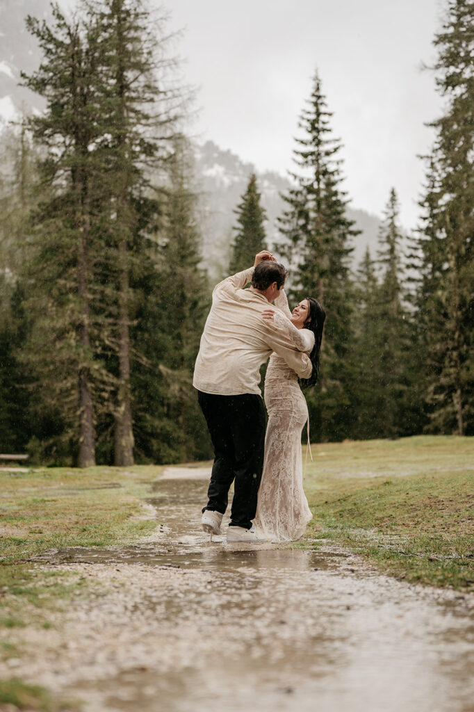 Couple dancing happily in rainy forest path