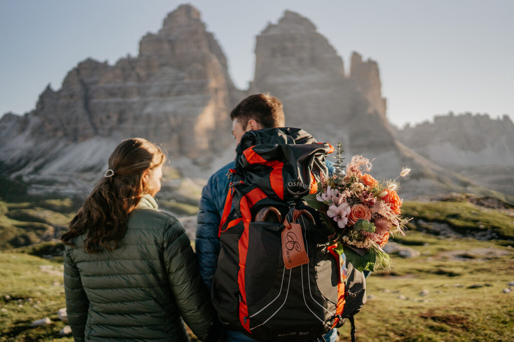 Couple hiking with flowers in mountains view.