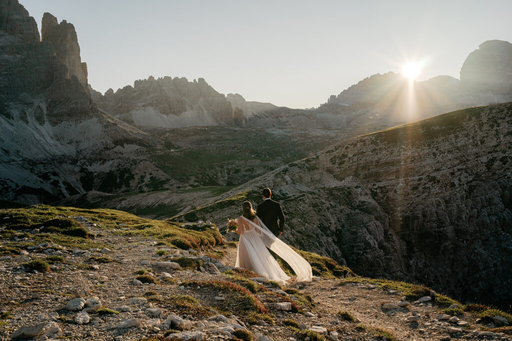 Couple hiking in mountains at sunrise.