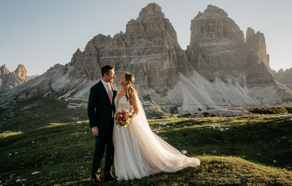 Couple in wedding attire by mountain backdrop