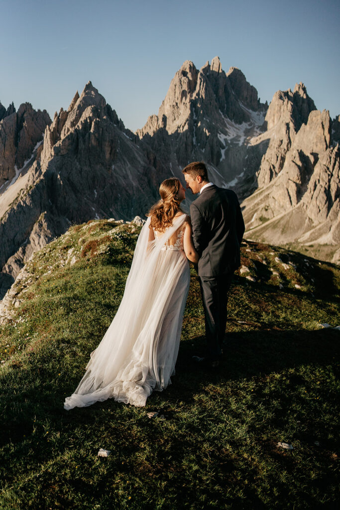 Bride and groom kissing on mountain summit