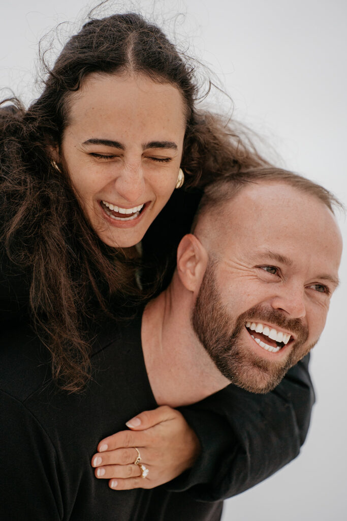 Couple laughing together, piggyback ride fun.